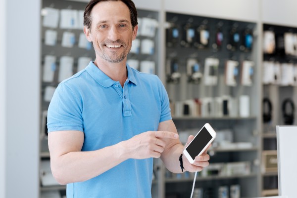 Un homme souriant à la boutique de téléphone