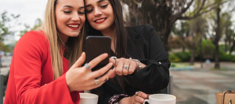 Deux jeunes femmes souriant devant le téléphone