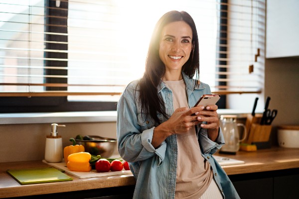 Tenir son téléphone en souriant 